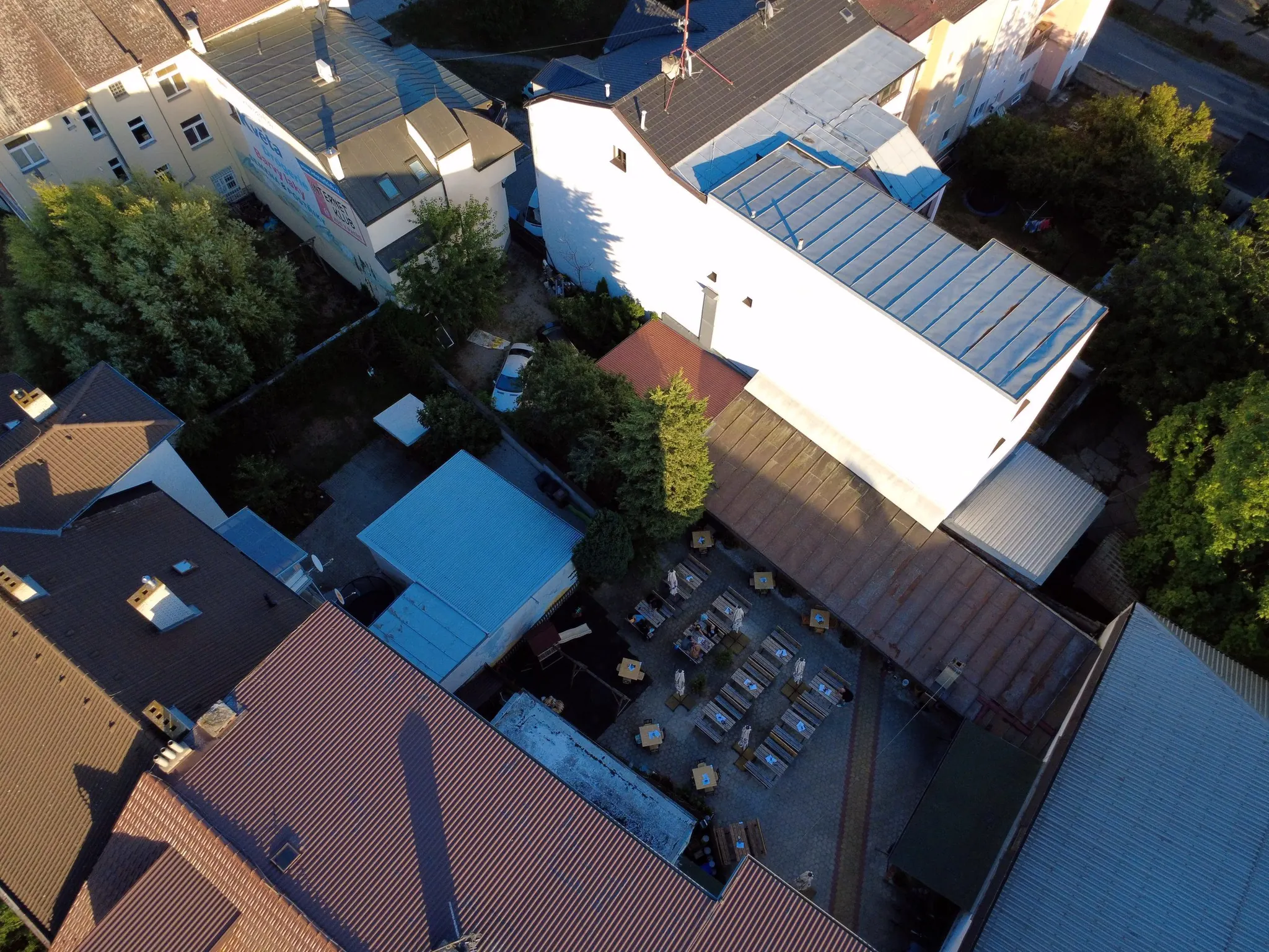 Letecký záběr střech v centru města se zahradní restaurací