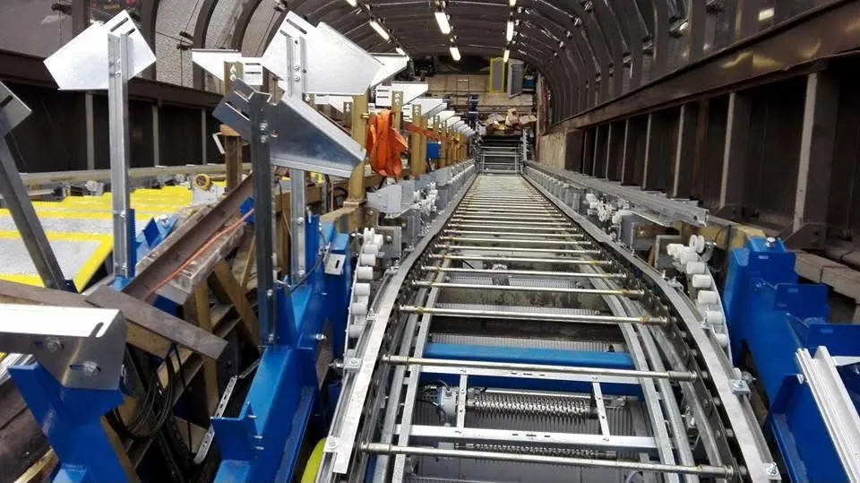 Dráha stupňového pásu s kladkami na modré montážní konstrukci